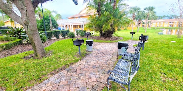 view of community featuring a pergola and a lawn