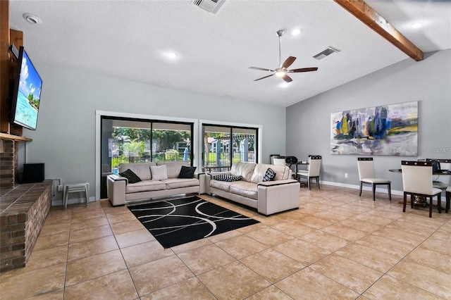 tiled living room with a textured ceiling, lofted ceiling with beams, a brick fireplace, and ceiling fan