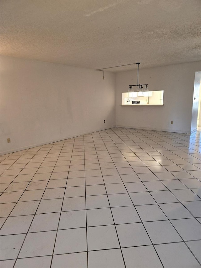 unfurnished room with light tile patterned floors and a textured ceiling