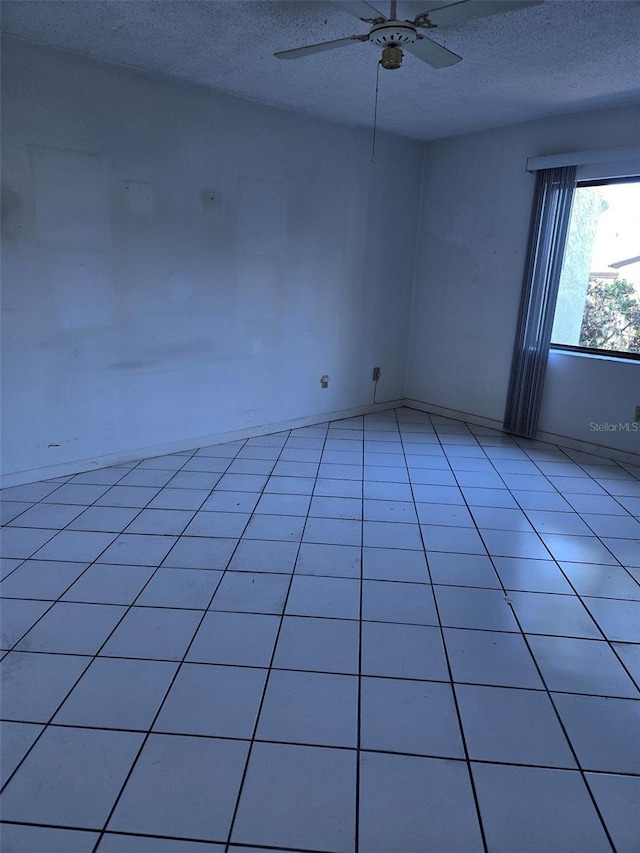 unfurnished room with light tile patterned floors, a textured ceiling, and ceiling fan