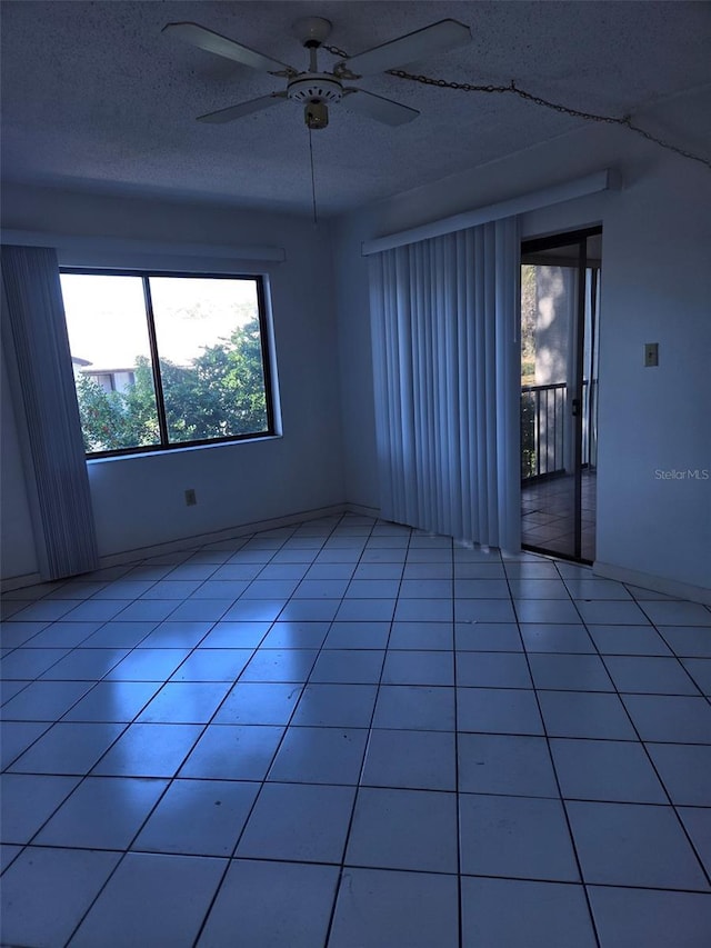 tiled spare room with ceiling fan and a textured ceiling