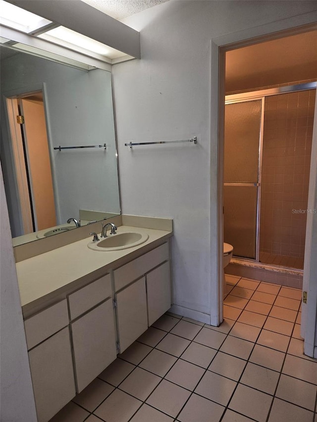 bathroom featuring toilet, vanity, tile patterned floors, and walk in shower