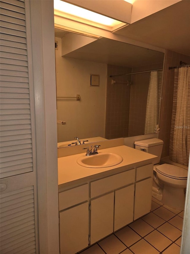 bathroom with tile patterned floors, walk in shower, vanity, and toilet