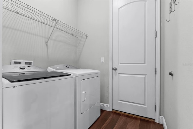 laundry room with dark wood-type flooring and separate washer and dryer