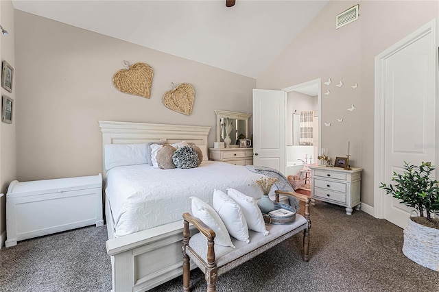 bedroom featuring dark carpet, ensuite bathroom, and high vaulted ceiling