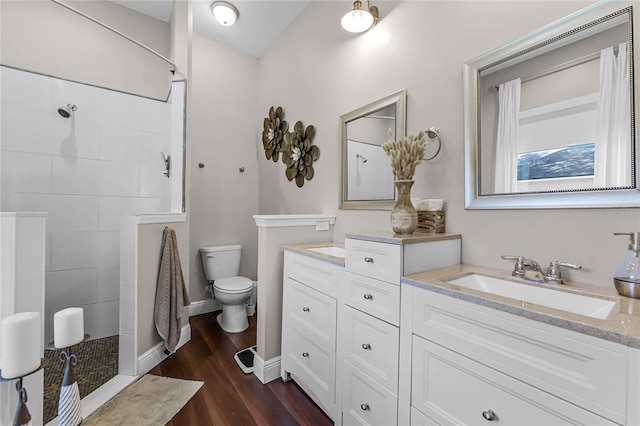 bathroom with walk in shower, vanity, hardwood / wood-style floors, and toilet