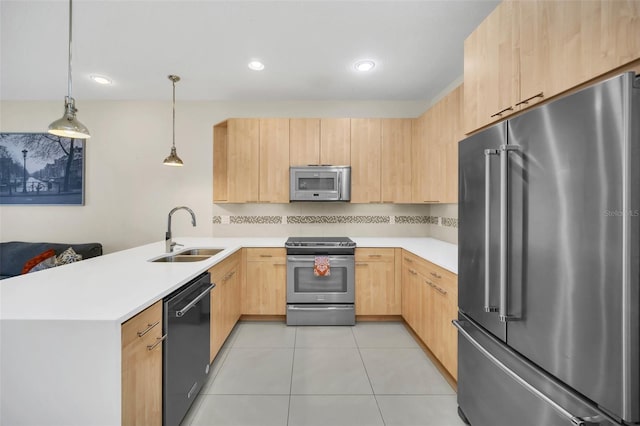 kitchen featuring pendant lighting, sink, kitchen peninsula, stainless steel appliances, and light brown cabinetry