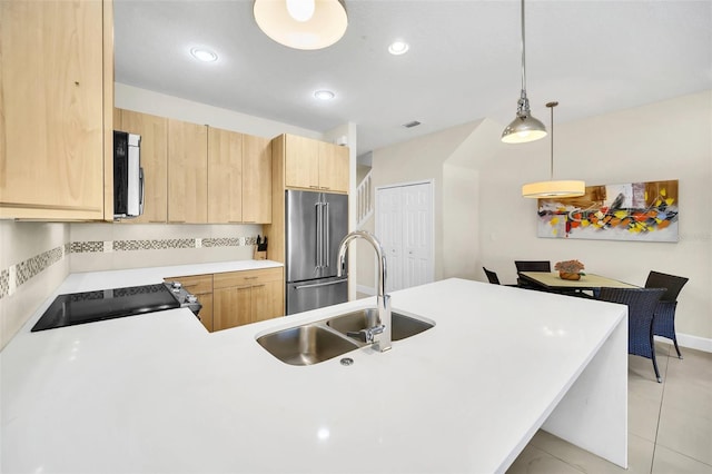 kitchen featuring pendant lighting, sink, high end refrigerator, black range oven, and light brown cabinets