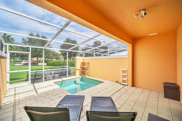 view of swimming pool featuring a jacuzzi, glass enclosure, and a patio area