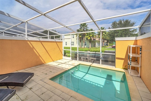 view of swimming pool featuring glass enclosure and a patio area