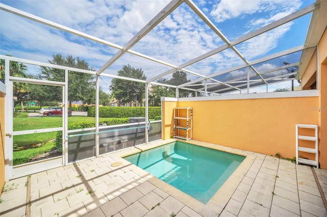 view of pool featuring glass enclosure and a patio area