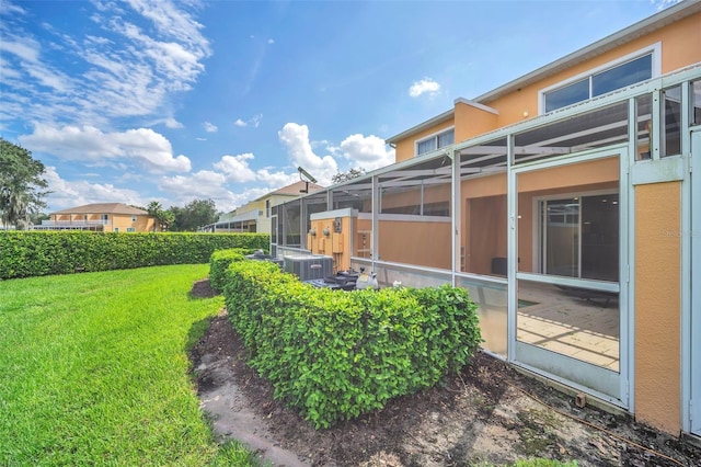 view of yard with a lanai and central AC unit