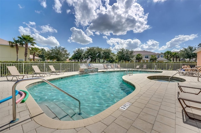 view of swimming pool featuring pool water feature, a hot tub, and a patio area