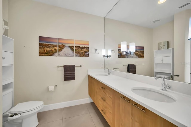 bathroom with tile patterned flooring, vanity, and toilet