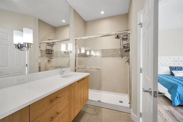 bathroom featuring walk in shower, wood-type flooring, and vanity