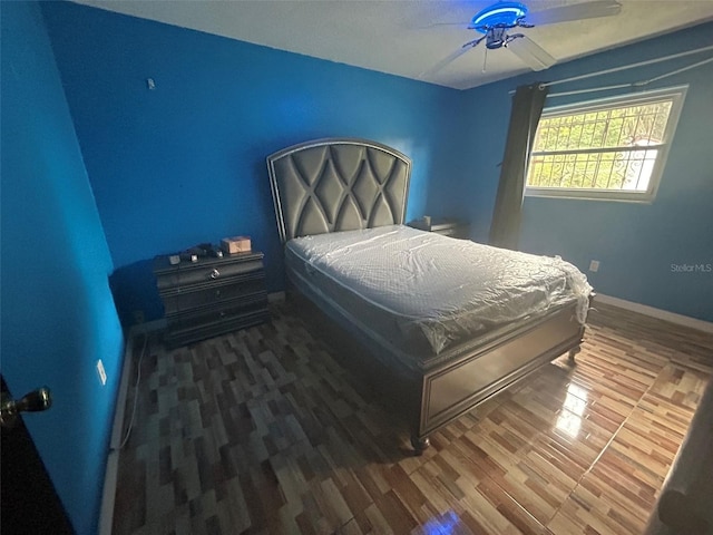 bedroom with dark hardwood / wood-style flooring and ceiling fan