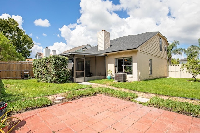 back of property with a patio, a sunroom, a yard, and central AC unit