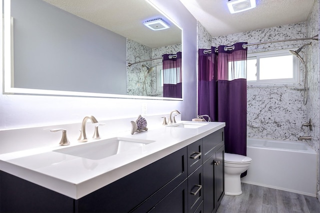 full bathroom featuring shower / tub combo with curtain, hardwood / wood-style flooring, vanity, toilet, and a textured ceiling