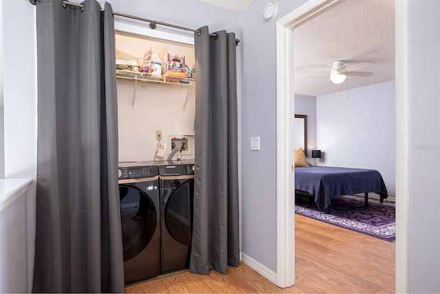 clothes washing area with separate washer and dryer, ceiling fan, light hardwood / wood-style floors, and a textured ceiling