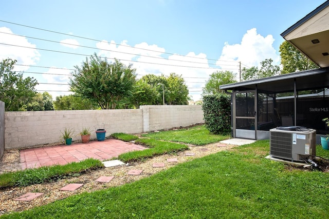 view of yard with a patio, a sunroom, and cooling unit