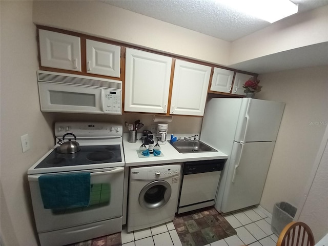 kitchen with light tile patterned flooring, sink, white appliances, white cabinetry, and washer / dryer