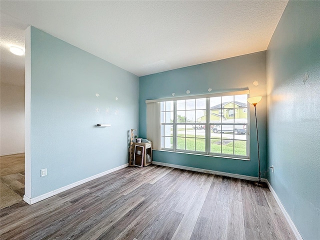 spare room featuring a textured ceiling and hardwood / wood-style flooring