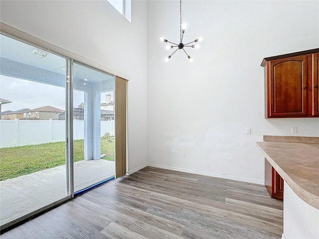 unfurnished dining area with light hardwood / wood-style floors and an inviting chandelier