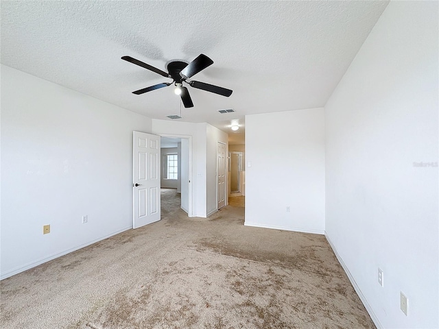 carpeted empty room featuring ceiling fan and a textured ceiling