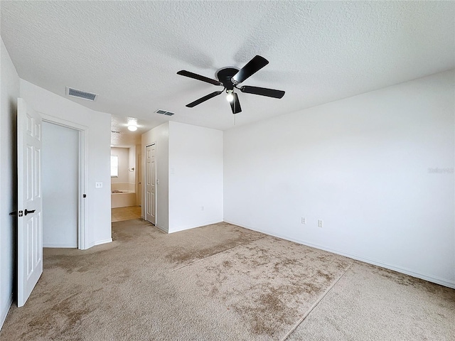 carpeted spare room featuring a textured ceiling and ceiling fan