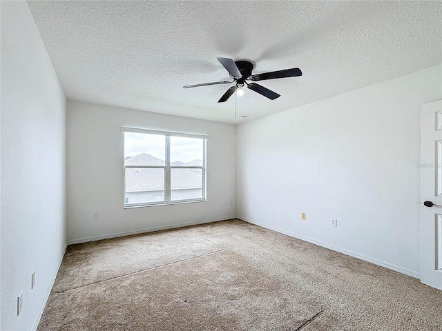 carpeted empty room with ceiling fan and a textured ceiling