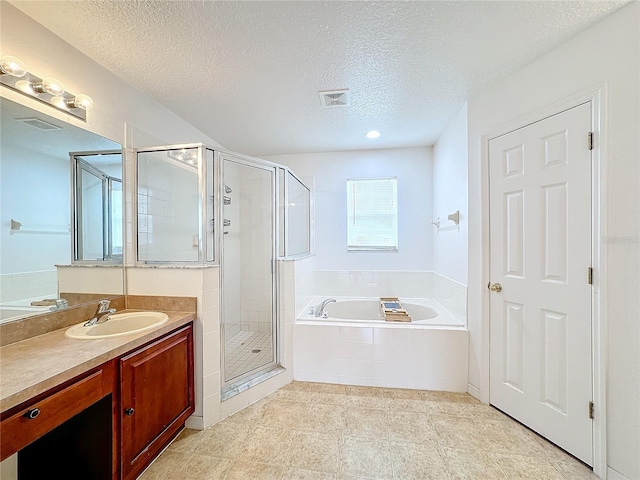 bathroom with vanity, shower with separate bathtub, a textured ceiling, and tile patterned floors