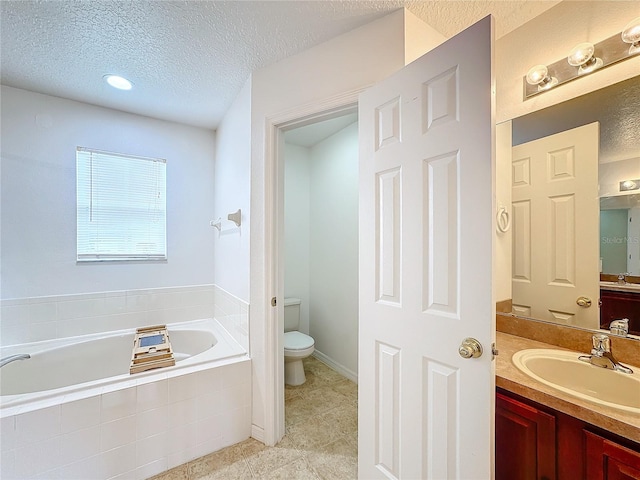 bathroom with tiled bath, tile patterned floors, vanity, a textured ceiling, and toilet