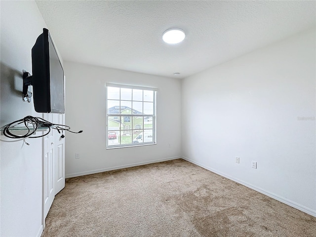 carpeted empty room featuring a textured ceiling