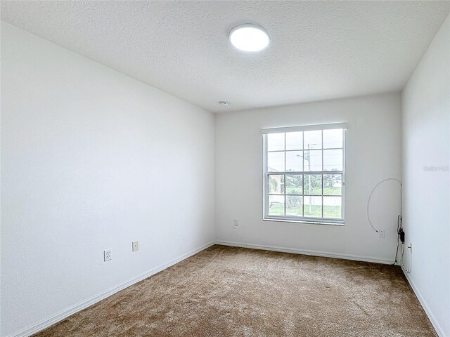 carpeted spare room with a textured ceiling