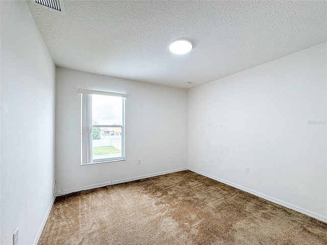 unfurnished room with a textured ceiling and carpet