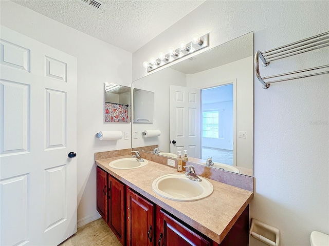 bathroom featuring vanity, a textured ceiling, and tile patterned floors