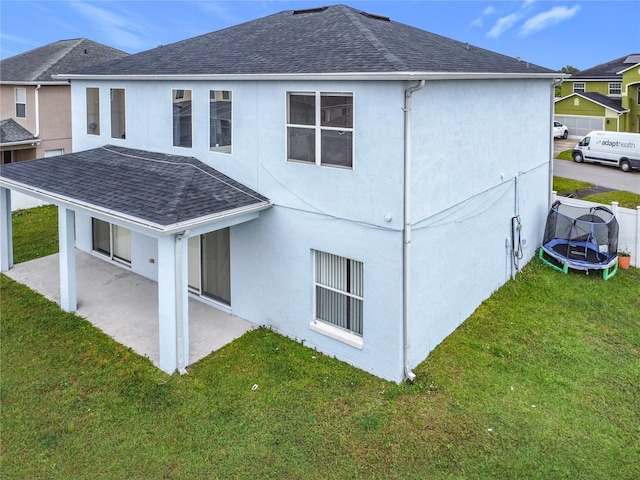 view of side of property featuring a patio area, a yard, and a trampoline