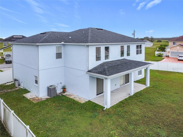 rear view of property featuring central AC, a yard, and a patio area