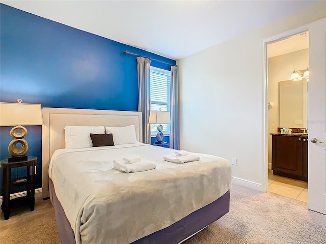 bedroom with light colored carpet and ensuite bathroom