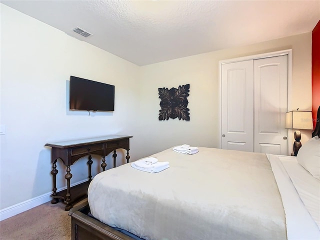 bedroom featuring carpet floors, a textured ceiling, and a closet