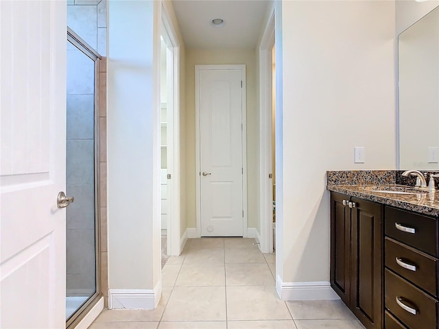 bathroom with walk in shower, vanity, and tile patterned flooring