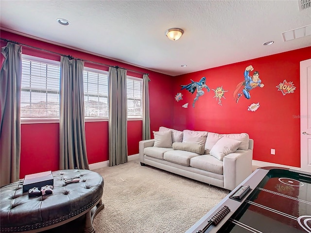 living room with a textured ceiling, carpet flooring, and a wealth of natural light