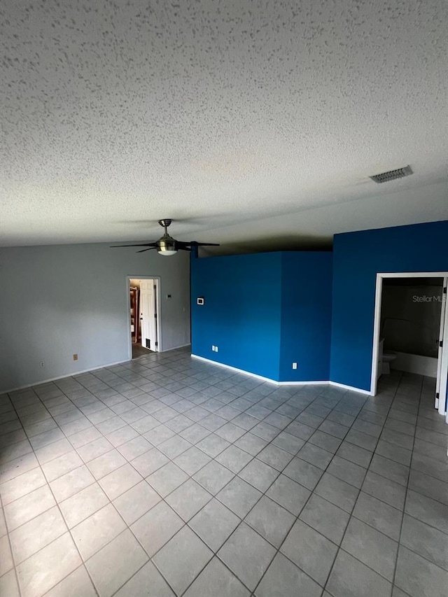 unfurnished living room with ceiling fan, light tile patterned floors, and a textured ceiling