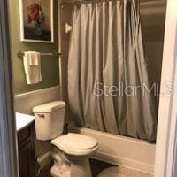 full bathroom with shower / tub combo, vanity, and toilet