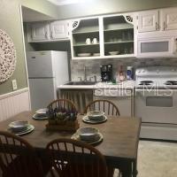 kitchen with white appliances, white cabinetry, and sink