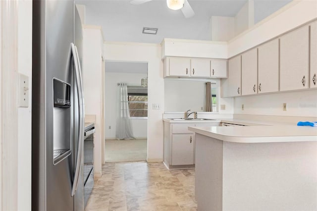 kitchen with ceiling fan, sink, kitchen peninsula, appliances with stainless steel finishes, and light colored carpet