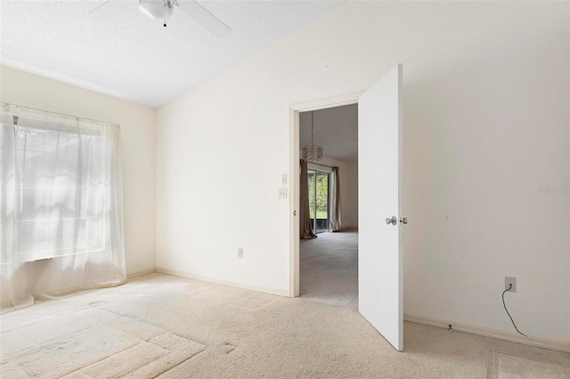 spare room featuring carpet floors, a textured ceiling, and ceiling fan