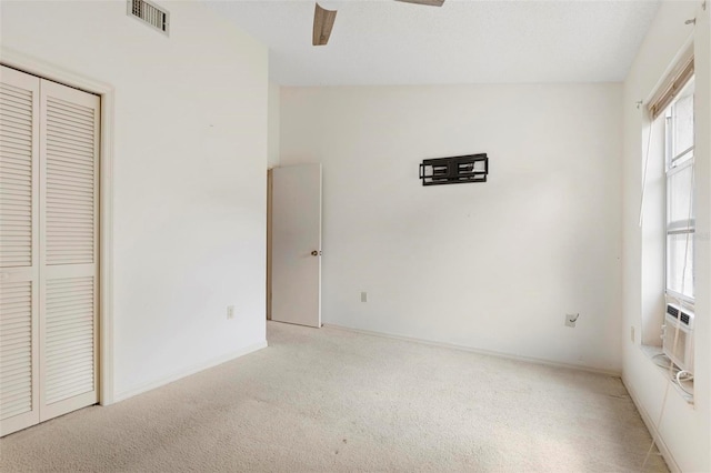 unfurnished bedroom with multiple windows, vaulted ceiling, ceiling fan, and light colored carpet