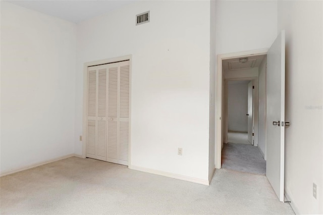 unfurnished bedroom with a closet and light colored carpet