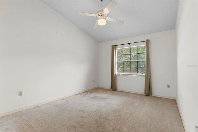 carpeted empty room with vaulted ceiling and ceiling fan